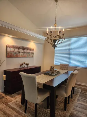 a view of a dining room with furniture a chandelier and wooden floor