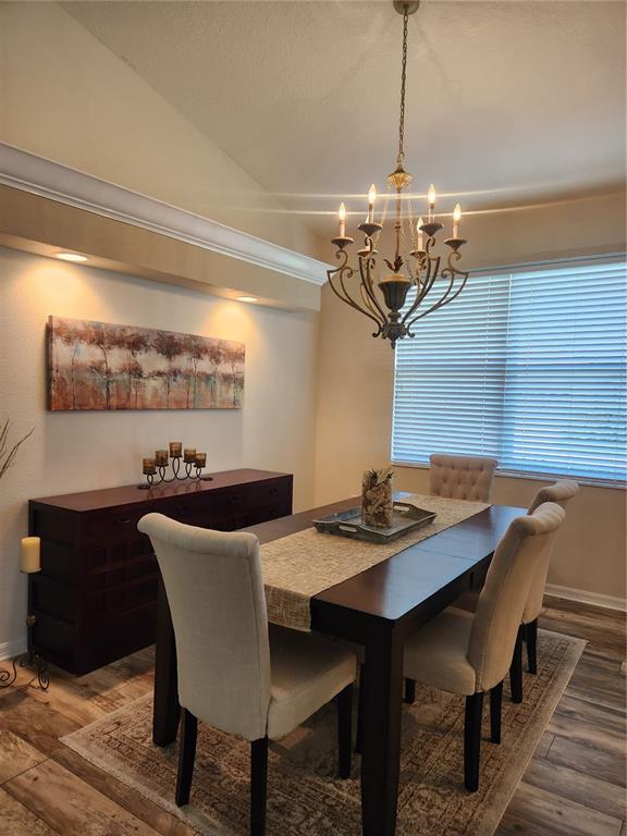 6496 Rookery Circle Bradenton, FL 34203 - Photo 7 of 40 a view of a dining room with furniture a chandelier and wooden floor