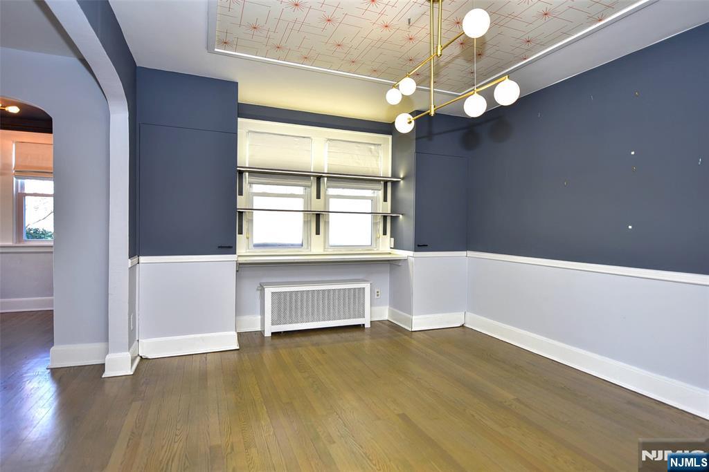 12-64 Burbank Street Fair Lawn, NJ 07410 - Photo 11 of 34 a view of an empty room with wooden floor and a window