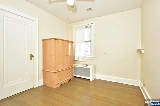 a view of a room with wooden floor and ceiling fan
