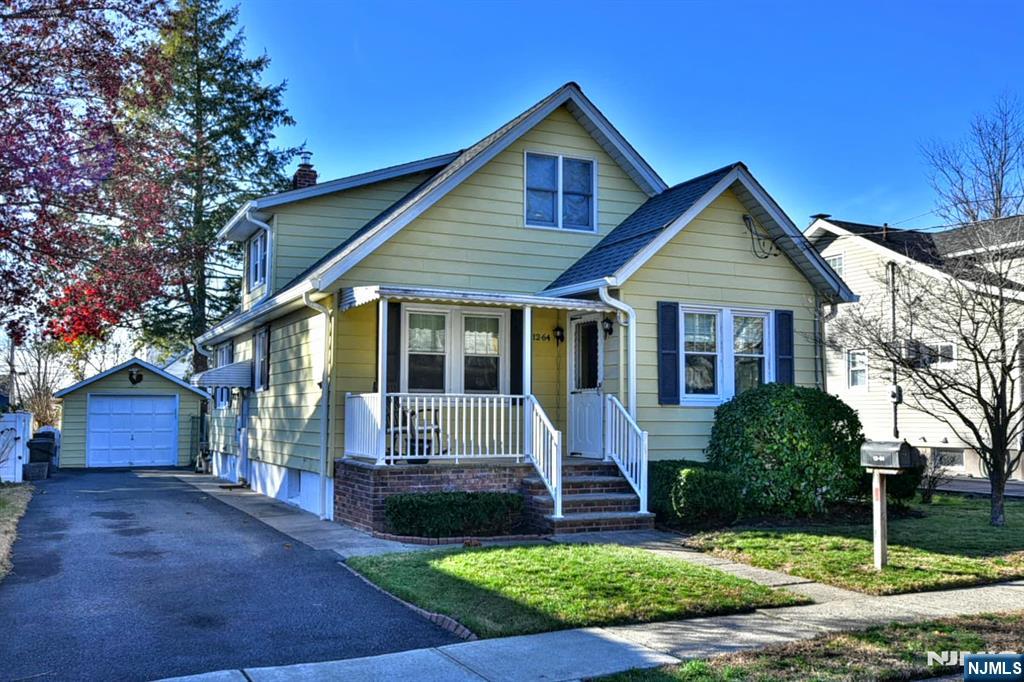 12-64 Burbank Street Fair Lawn, NJ 07410 - Photo 2 of 34 a front view of a house with a yard and garage