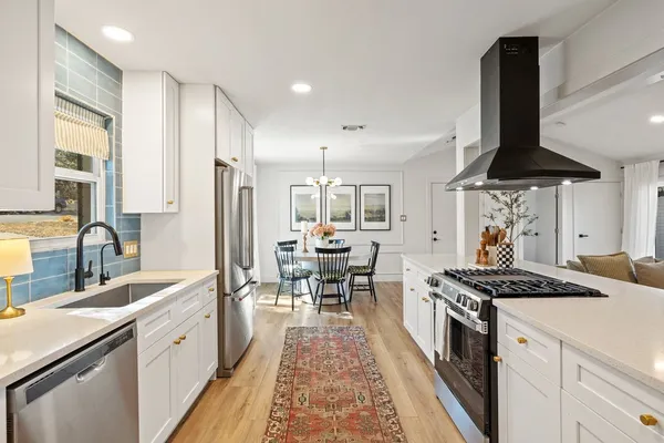 a kitchen with stainless steel appliances a sink stove and cabinets