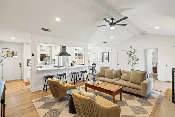 a living room with furniture and a wooden floor
