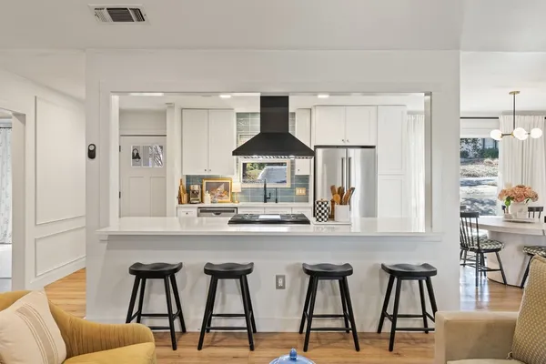 a kitchen with stainless steel appliances granite countertop a table and chairs in it