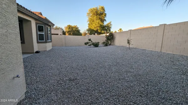 a view of a house with wooden walls and a yard