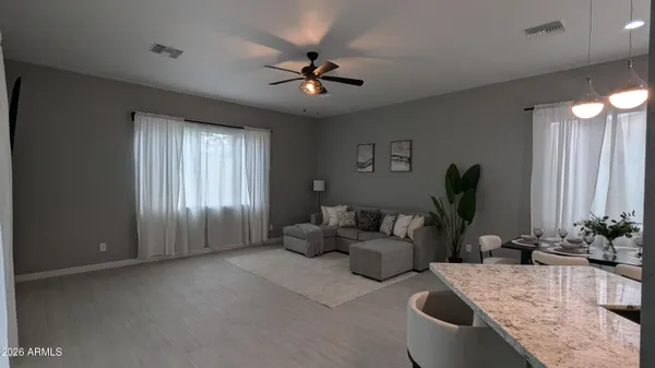 a living room with furniture and potted plants