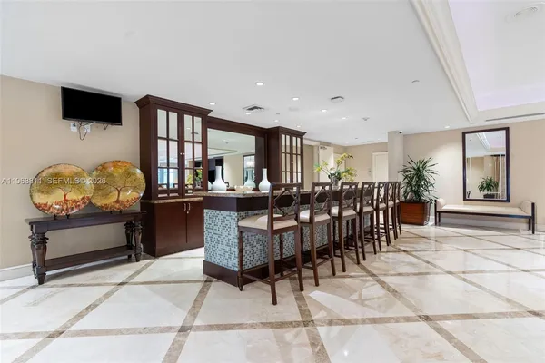 a living room with lots of furniture a chandelier and a glass table with chairs