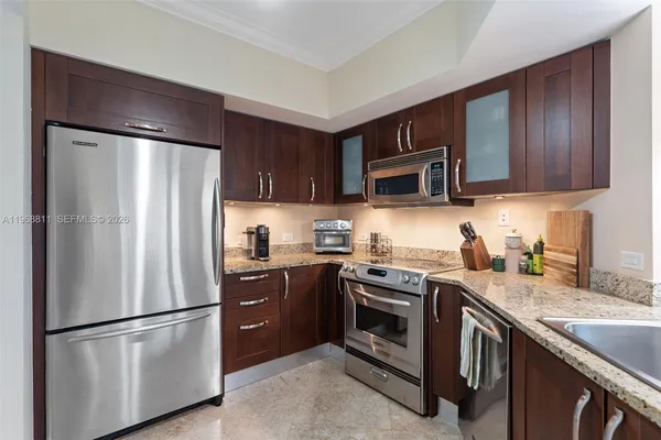 a kitchen with stainless steel appliances granite countertop a refrigerator stove a sink dishwasher and microwave