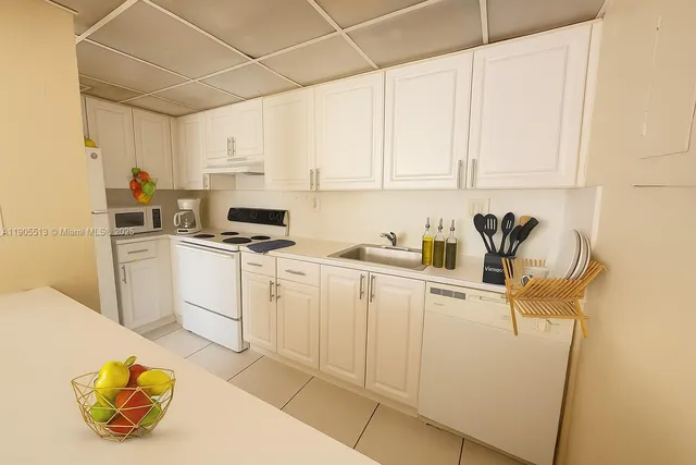 a kitchen with white cabinets and white appliances