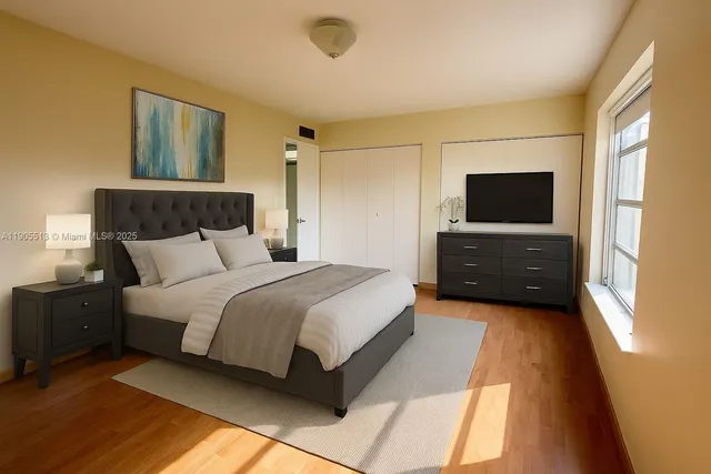 a bedroom with a bed and a flat screen tv