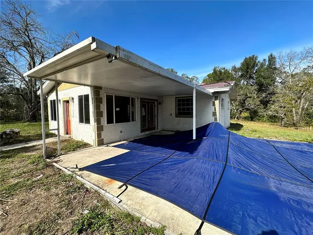a view of a house with a yard and potted plants