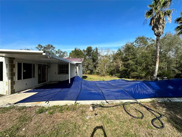 a view of a house with backyard and sitting area