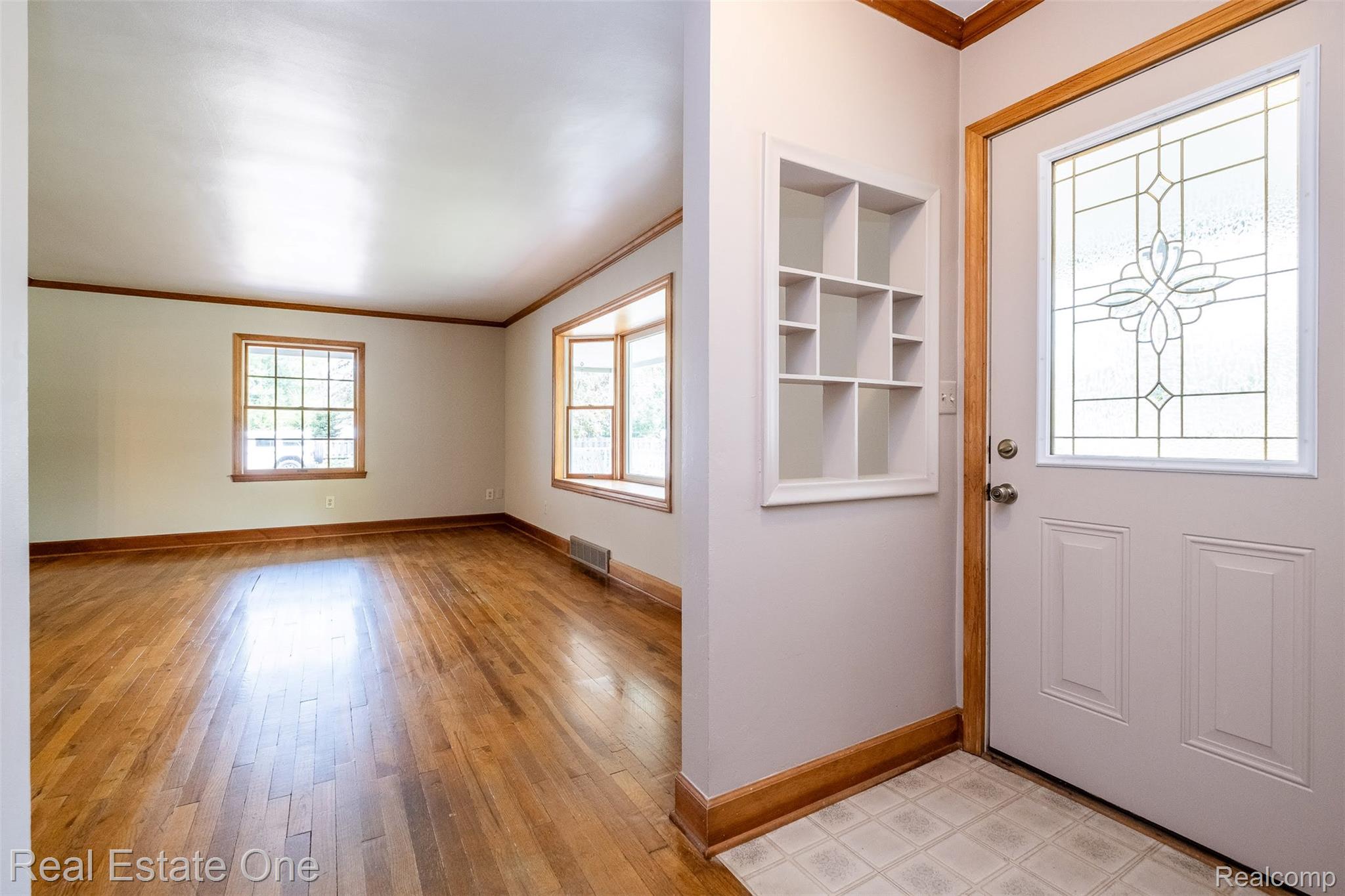 11030 Marshall Road South Lyon, MI 48178 - Photo 17 of 83 Hardwood flooring, decorative front entry door with leaded glass, built-in wall shelving, bay window, and a secondary window with wood trim