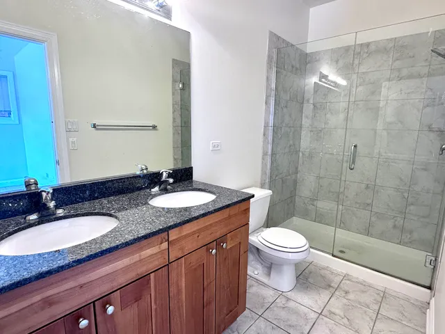 a bathroom with a granite countertop sink toilet and shower