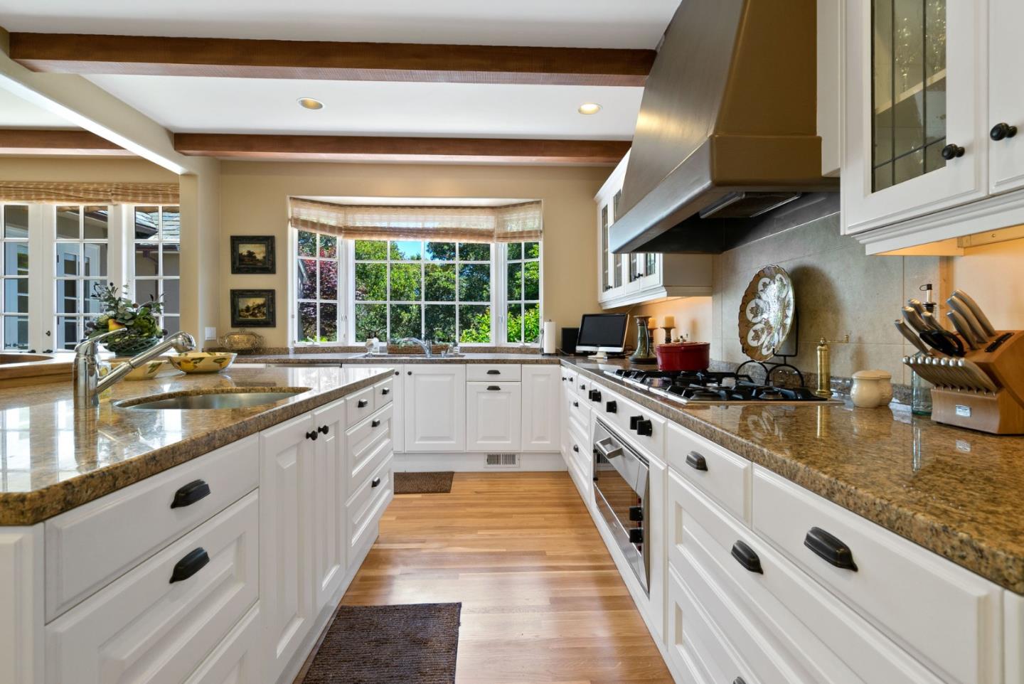 25951 Ridgewood Road Carmel, CA 93923 - Photo 14 of 32 a large white kitchen with granite countertop a sink and dishwasher a stove with wooden floor