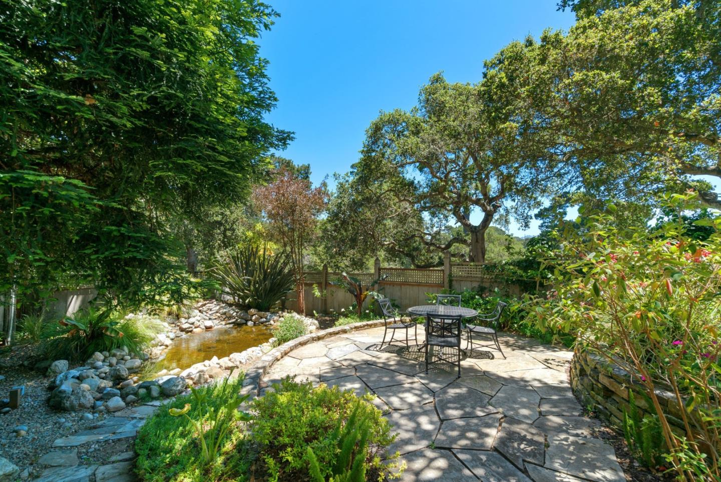 25951 Ridgewood Road Carmel, CA 93923 - Photo 32 of 32 a backyard of a house with table and chairs under an umbrella