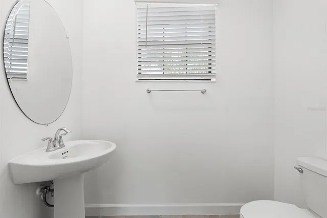 a bathroom with a sink toilet and a mirror