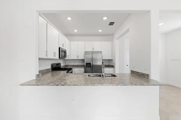 a kitchen with kitchen island granite countertop a sink and a counter top space