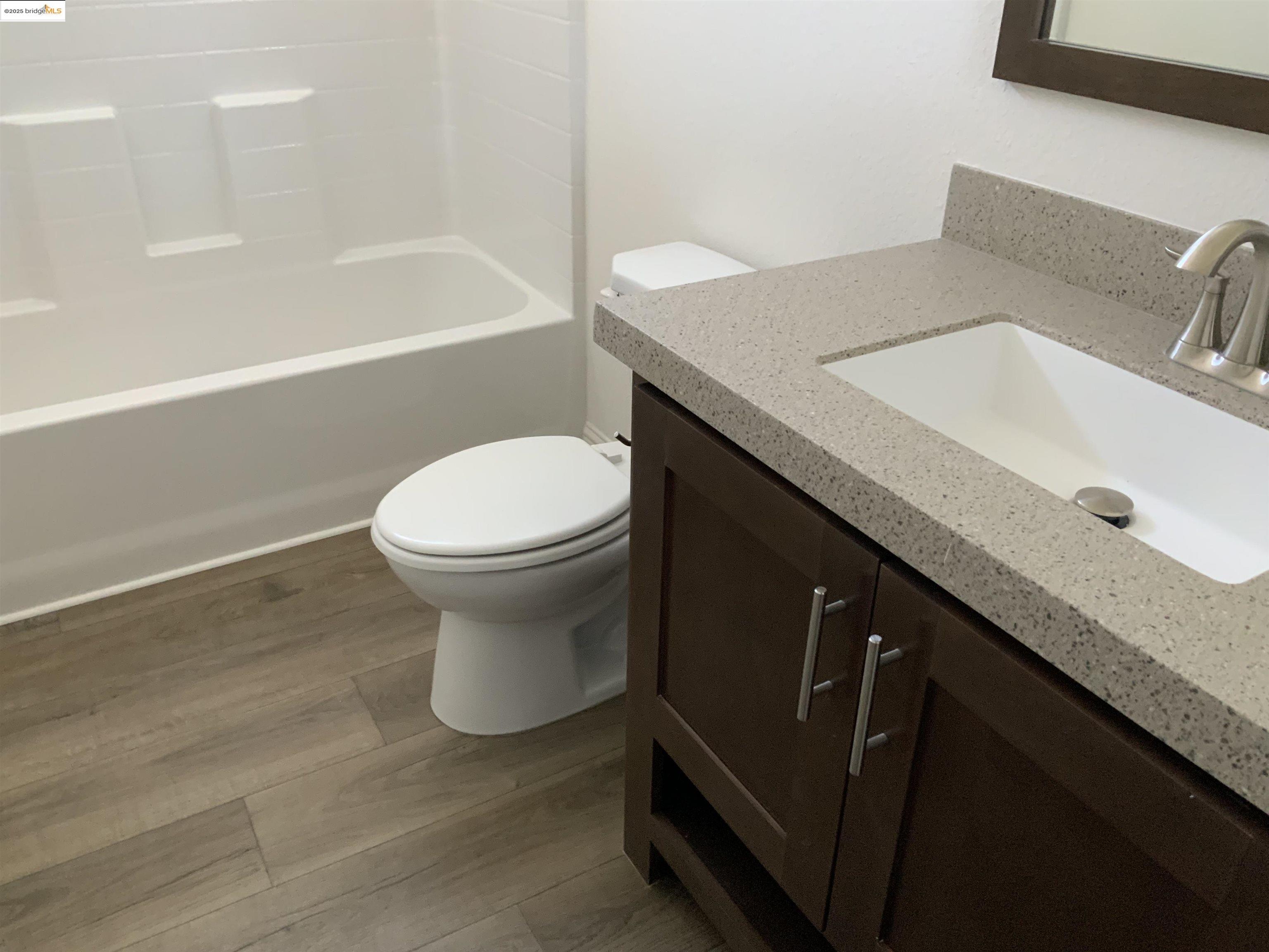 77 Hilo Drive Pittsburg, CA 94565 - Photo 14 of 23 a bathroom with a granite countertop sink a toilet and bathtub