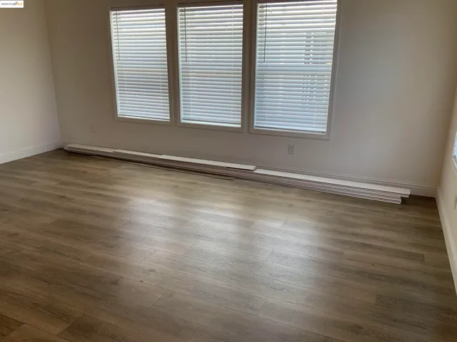 an empty room with wooden floor and a window