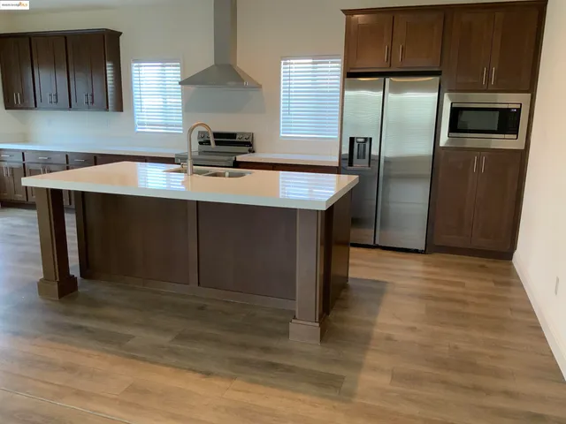 a kitchen with kitchen island a sink appliances and cabinets