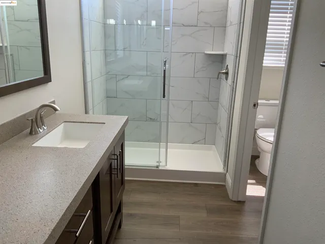 a bathroom with a sink a toilet and shower