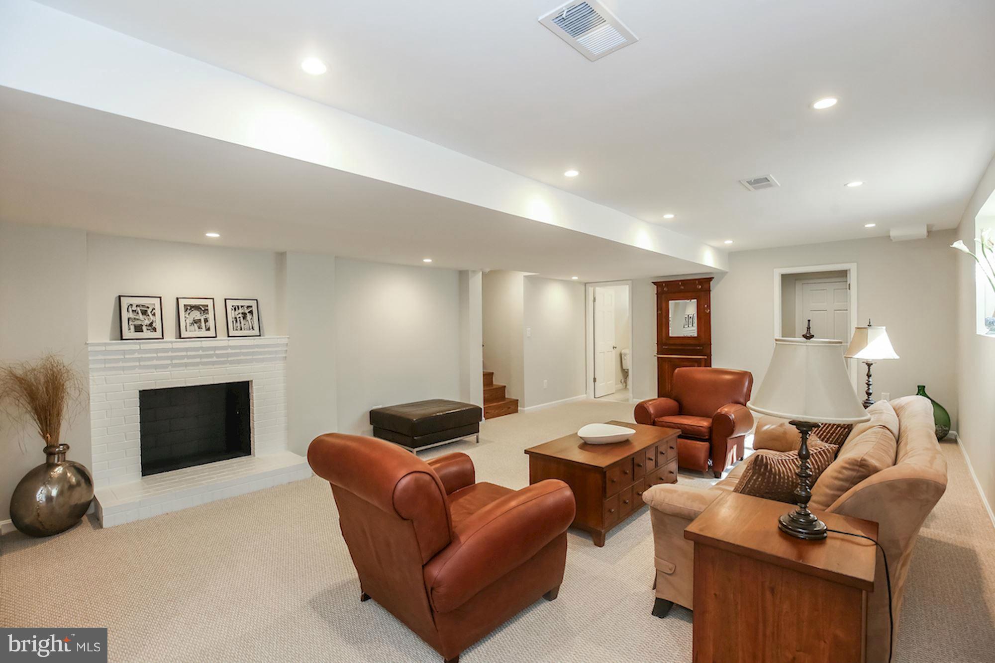2347 49th Street Northwest Washington, DC 20007 - Photo 17 of 29 a living room with furniture a fireplace and a flat screen tv