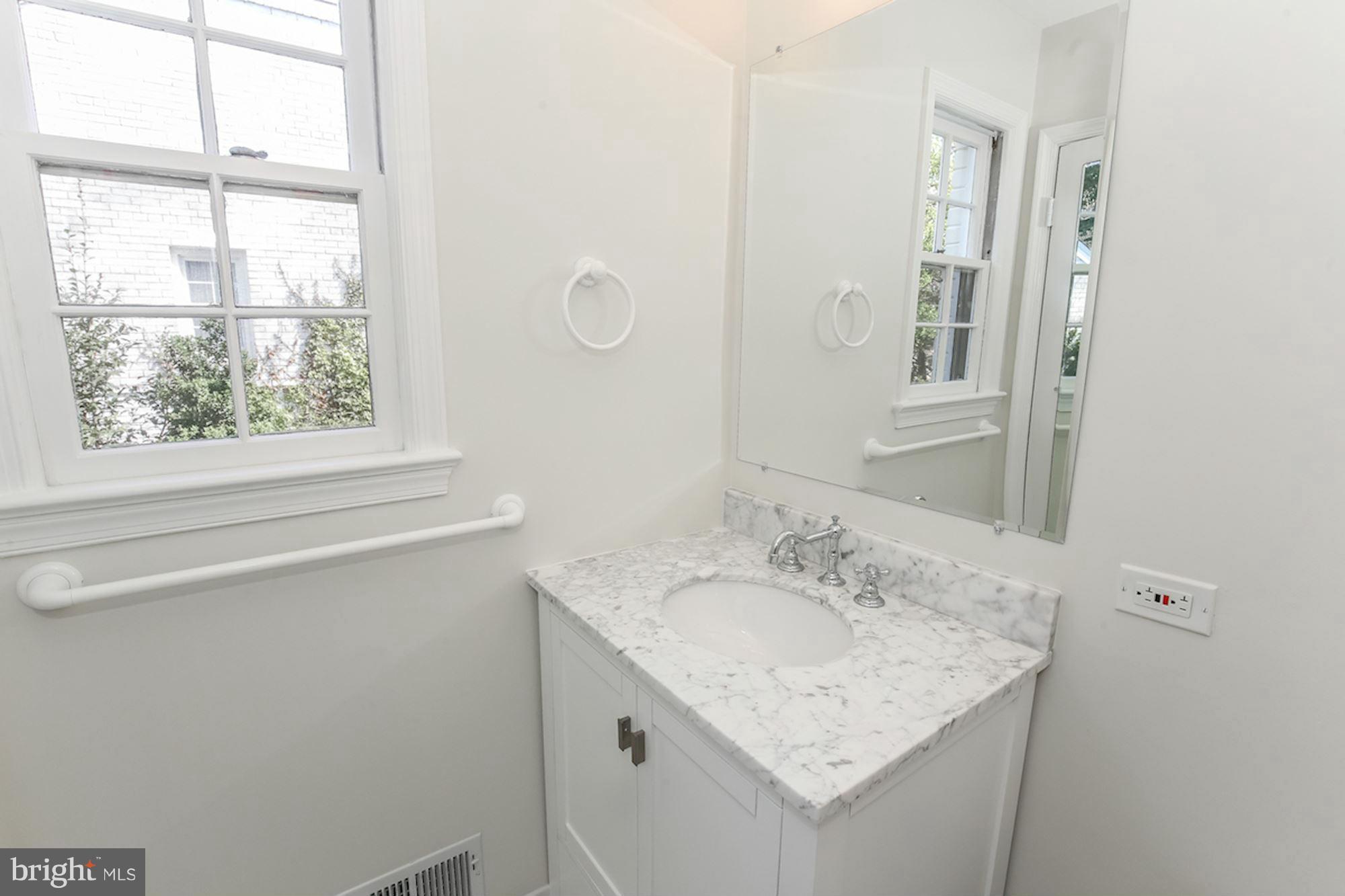 2347 49th Street Northwest Washington, DC 20007 - Photo 23 of 29 a bathroom with a granite countertop sink a mirror and a window