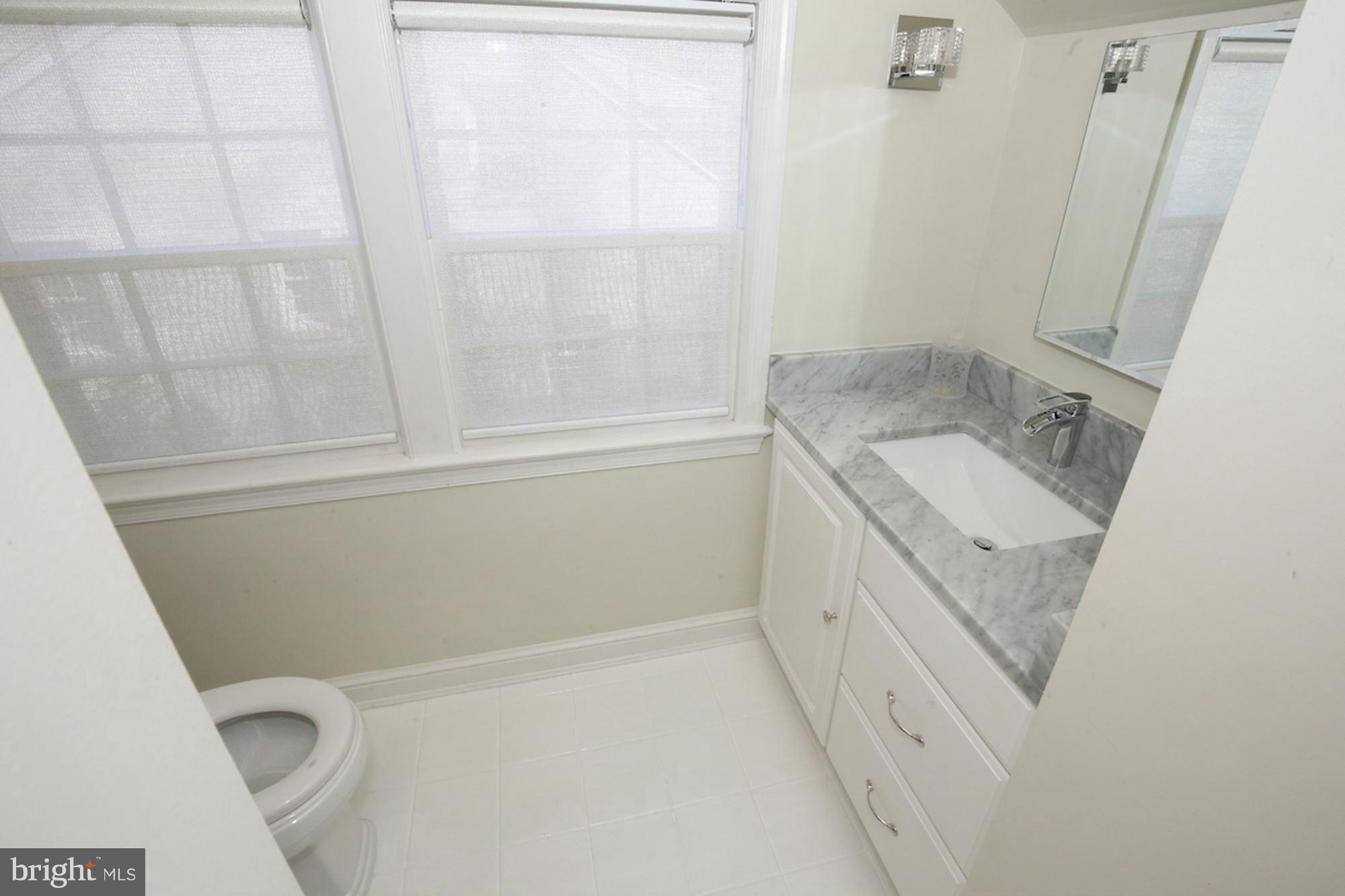 2347 49th Street Northwest Washington, DC 20007 - Photo 29 of 29 a bathroom with a granite countertop sink a toilet and a bathtub