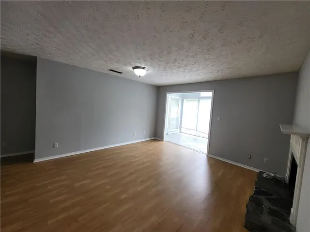 a view of a room with wooden floor and floor to ceiling window