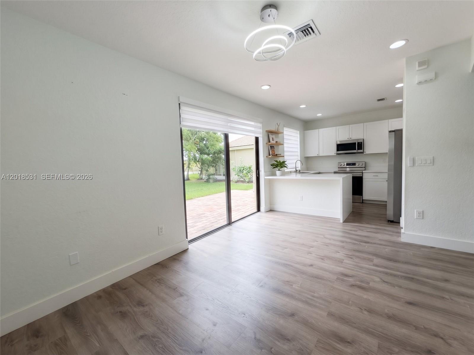 1575 Southeast 20th Road Homestead, FL 33035 - Photo 4 of 19 a view of a kitchen with a stove cabinets and wooden floor