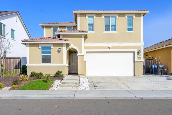 a front view of a house with a yard and garage