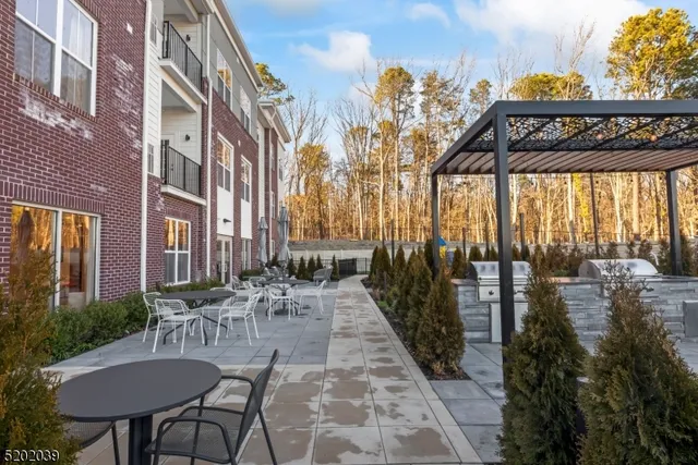 a open kitchen with stainless steel appliances granite countertop a stove and white cabinets