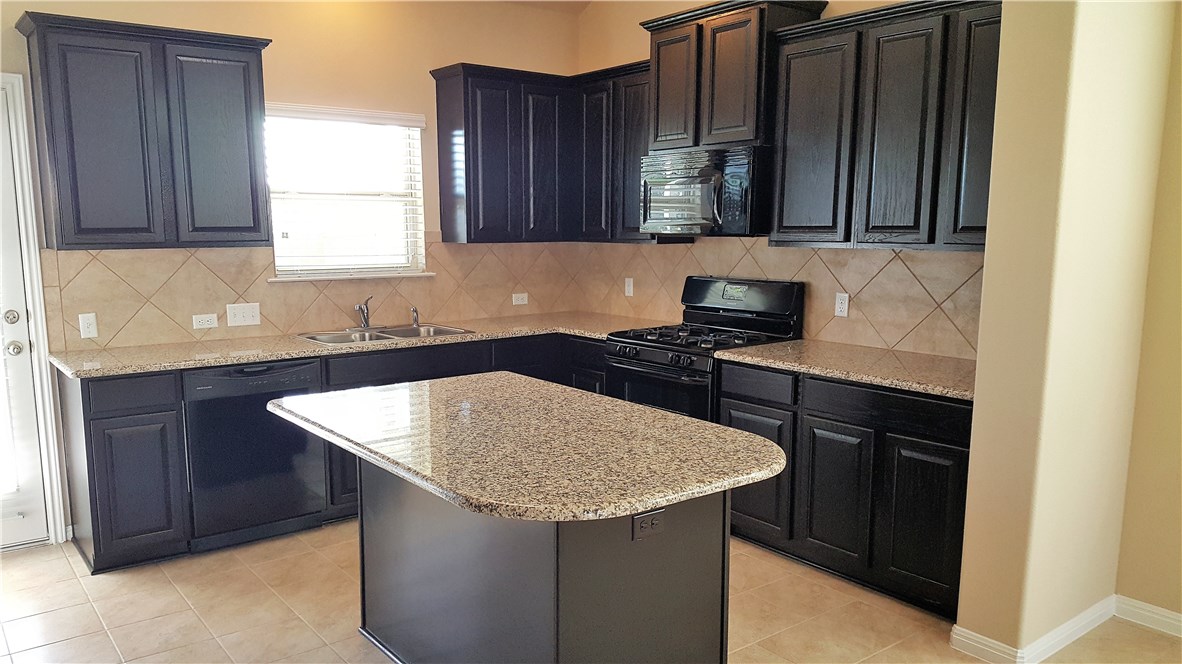 1509 Hamiltons Way Leander, TX 78641 - Photo 8 of 34 Kitchen - granite counters and gas stove and microwave