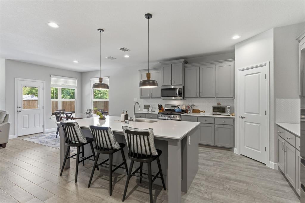 5621 Round Hl Road Denton, TX 76210 - Photo 5 of 27 a kitchen with kitchen island a dining table chairs sink and cabinets