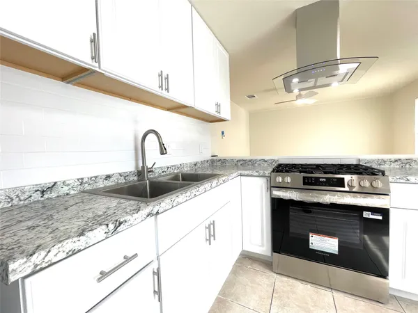 a kitchen with granite countertop a stove top oven and sink