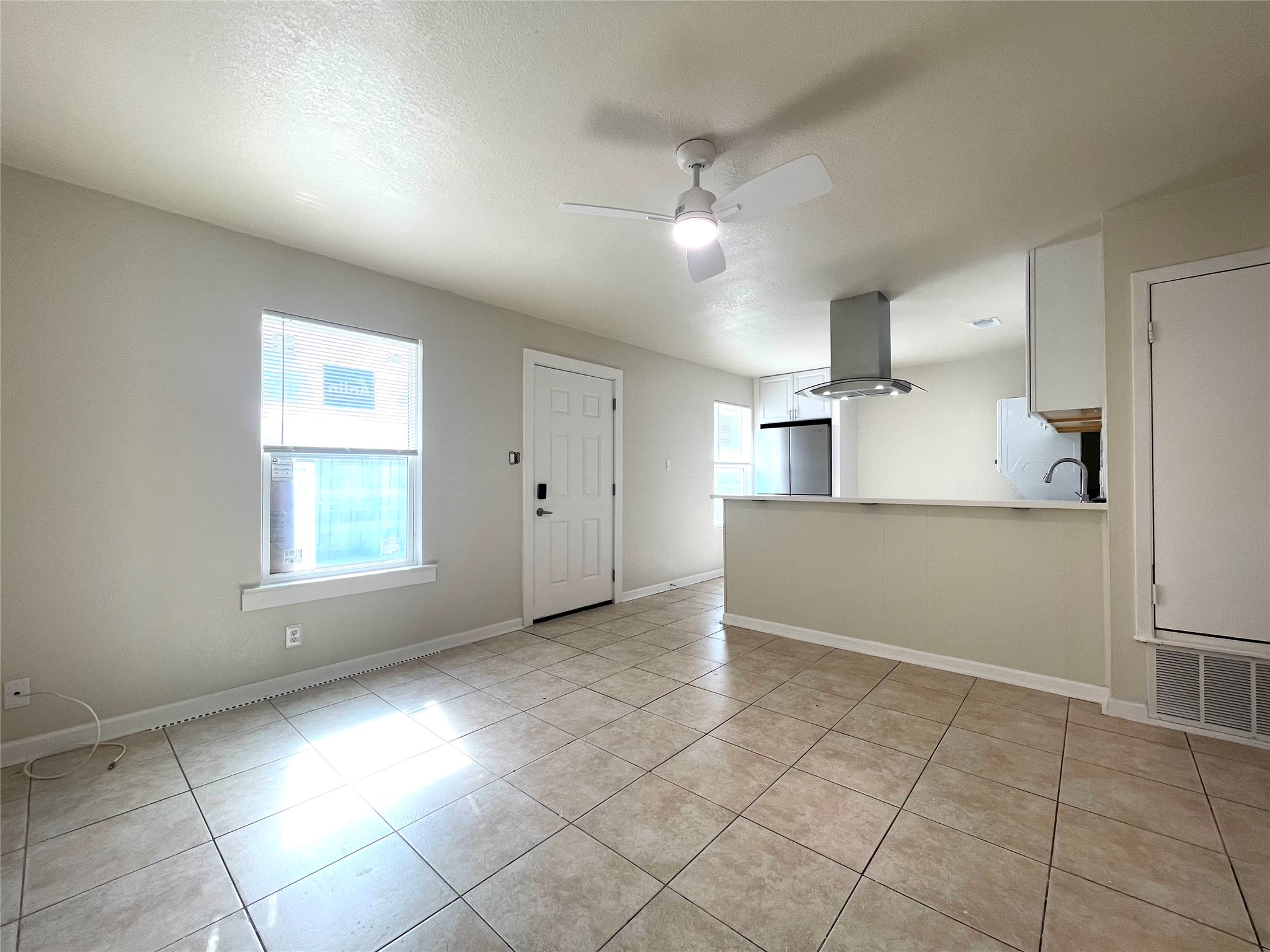 6510 Hickman Avenue, Unit 102 Austin, TX 78723 - Photo 19 of 32 Unfurnished living room featuring a ceiling fan and light tile patterned flooring