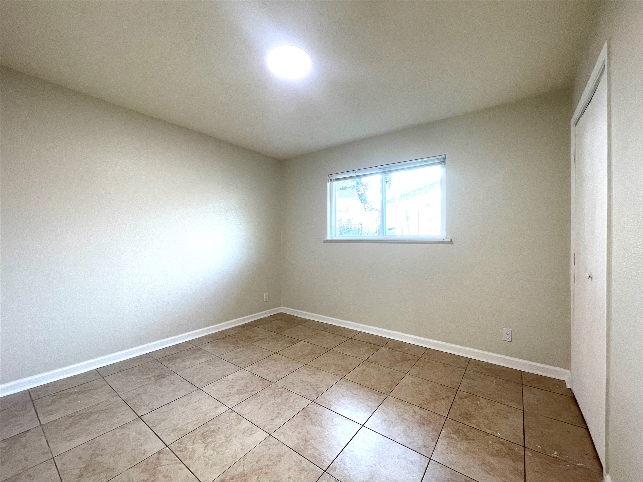 6510 Hickman Avenue, Unit 102 Austin, TX 78723 - Photo 26 of 32 Unfurnished bedroom with a closet and light tile patterned flooring