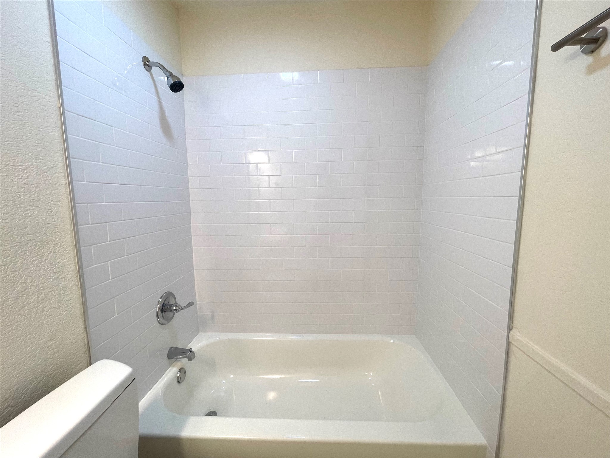 6510 Hickman Avenue, Unit 102 Austin, TX 78723 - Photo 28 of 32 Bathroom featuring a textured wall and bathing tub / shower combination