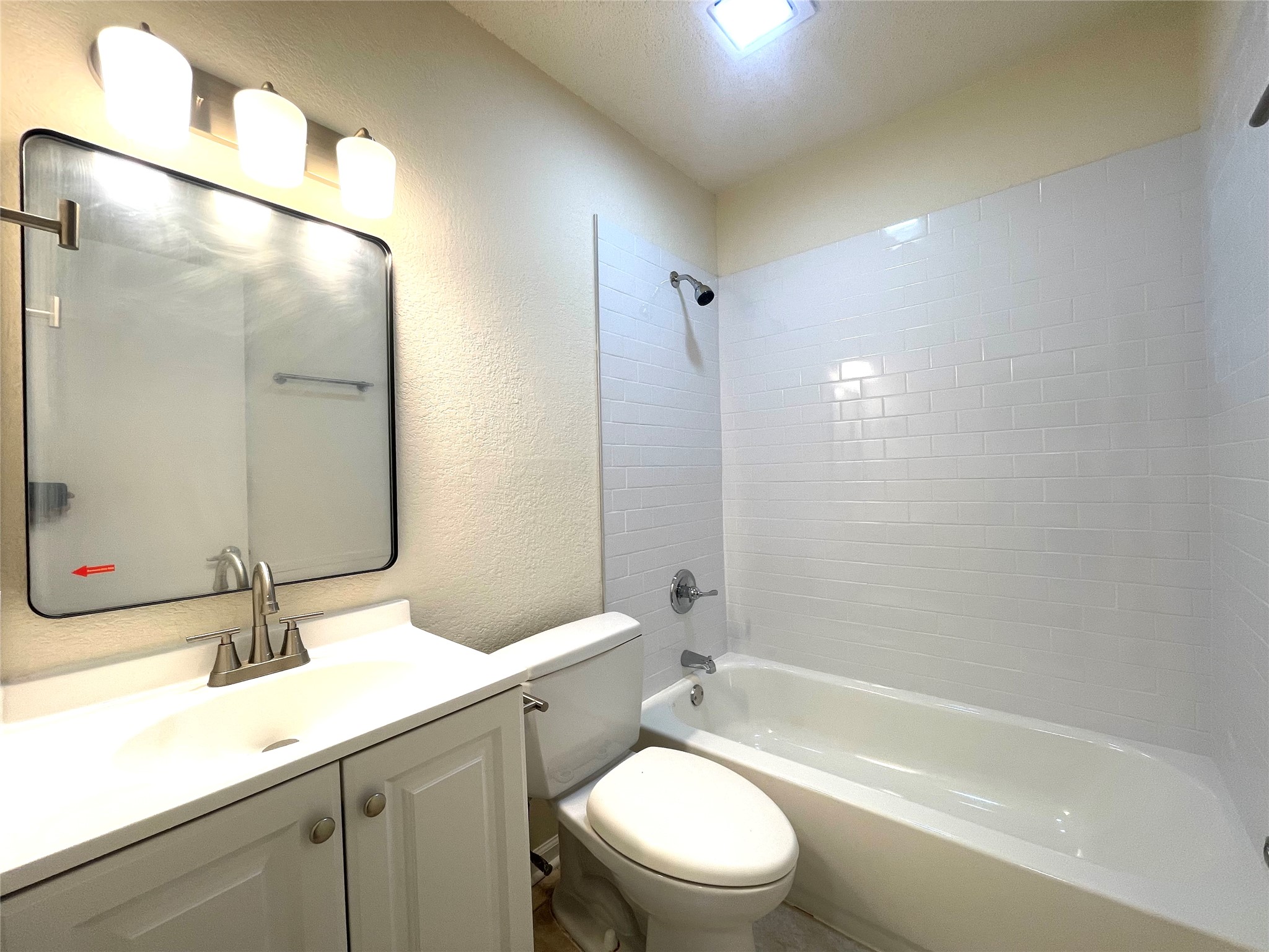 6510 Hickman Avenue, Unit 102 Austin, TX 78723 - Photo 29 of 32 Full bath featuring a textured wall, vanity, and shower combination