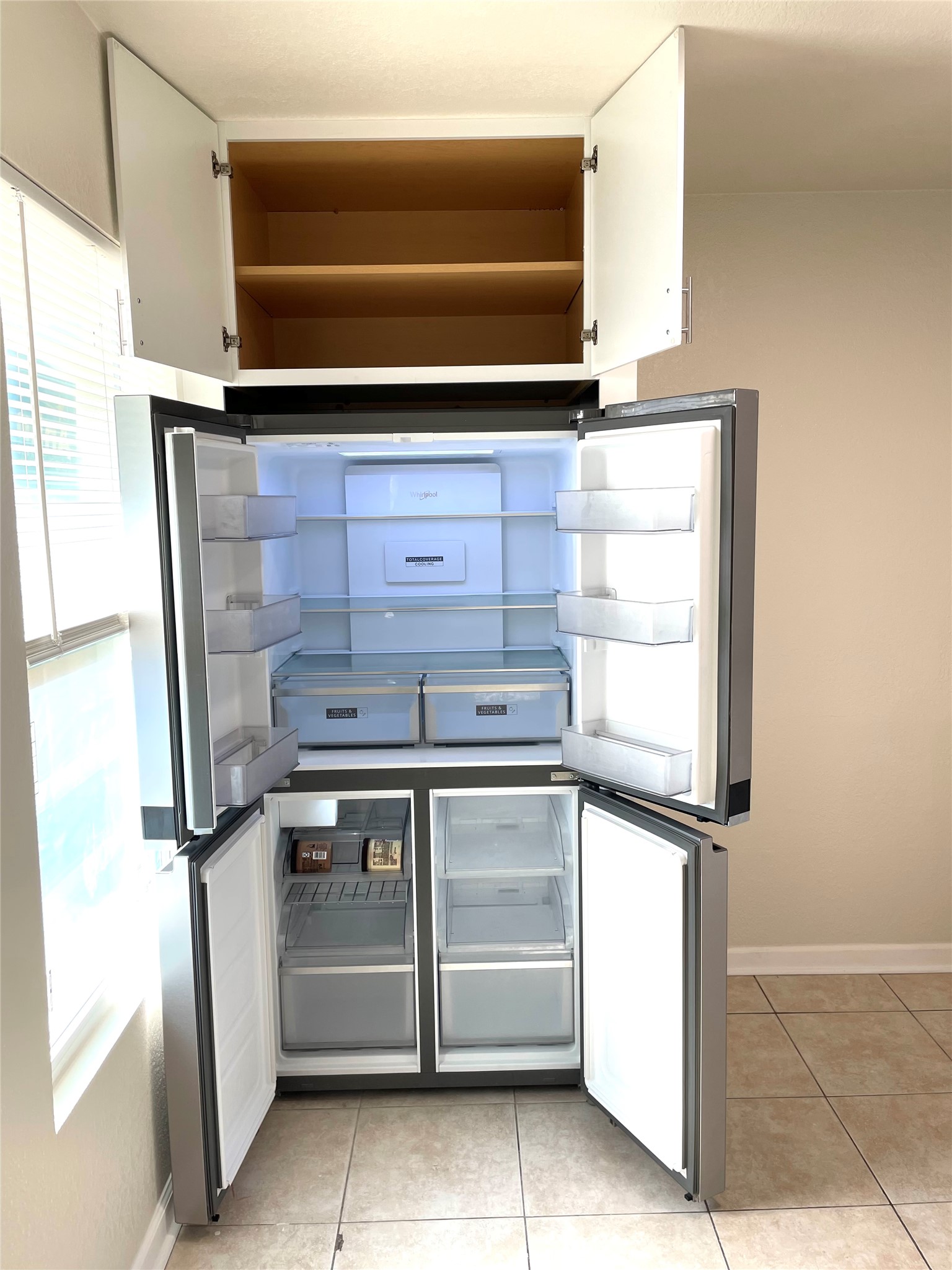6510 Hickman Avenue, Unit 102 Austin, TX 78723 - Photo 32 of 32 Kitchen featuring freestanding refrigerator, light tile patterned floors, and white cabinets