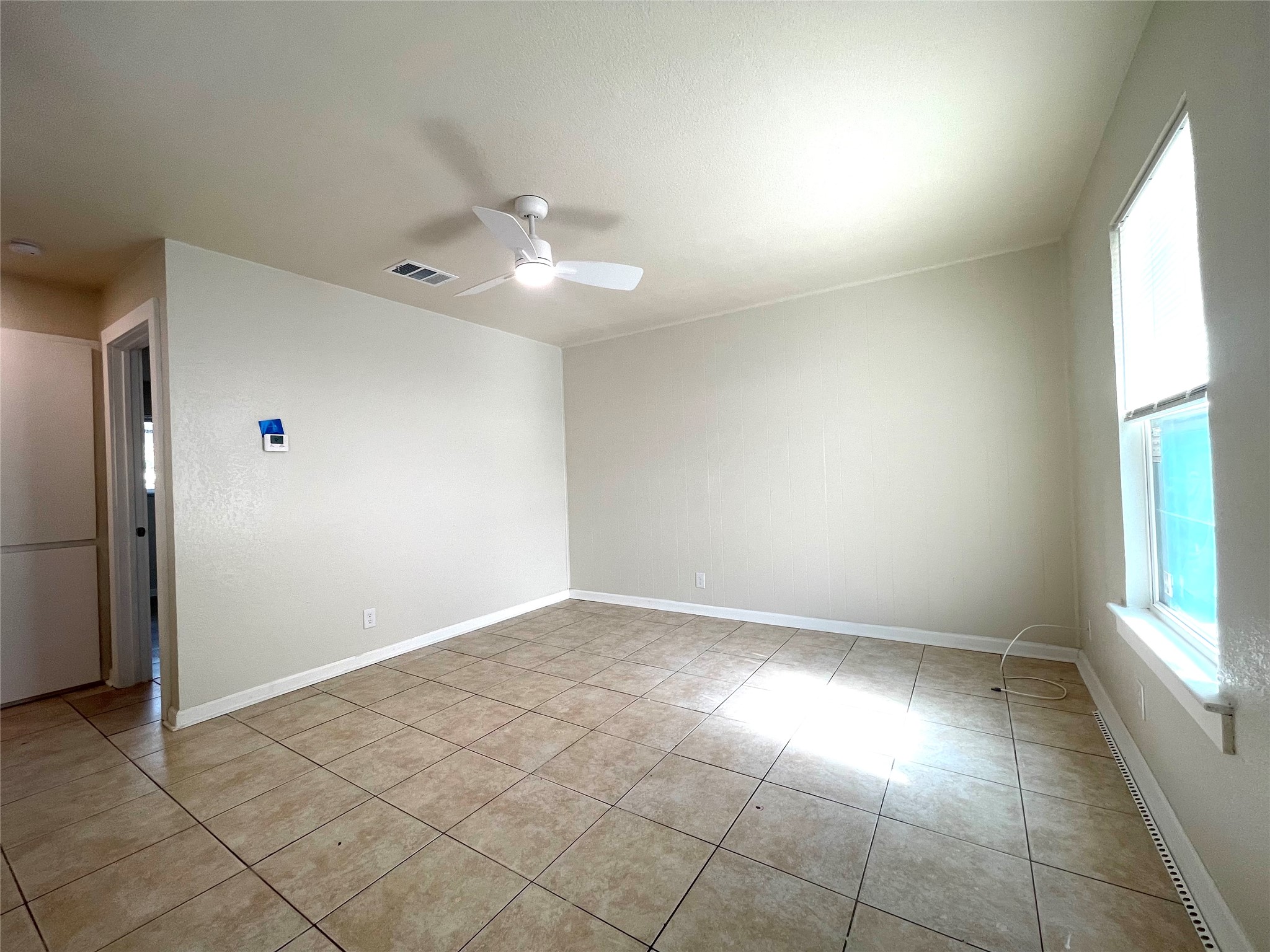 6510 Hickman Avenue, Unit 102 Austin, TX 78723 - Photo 9 of 32 Unfurnished room featuring a ceiling fan and light tile patterned floors