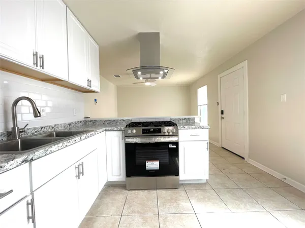 a kitchen with a stove top oven and cabinets