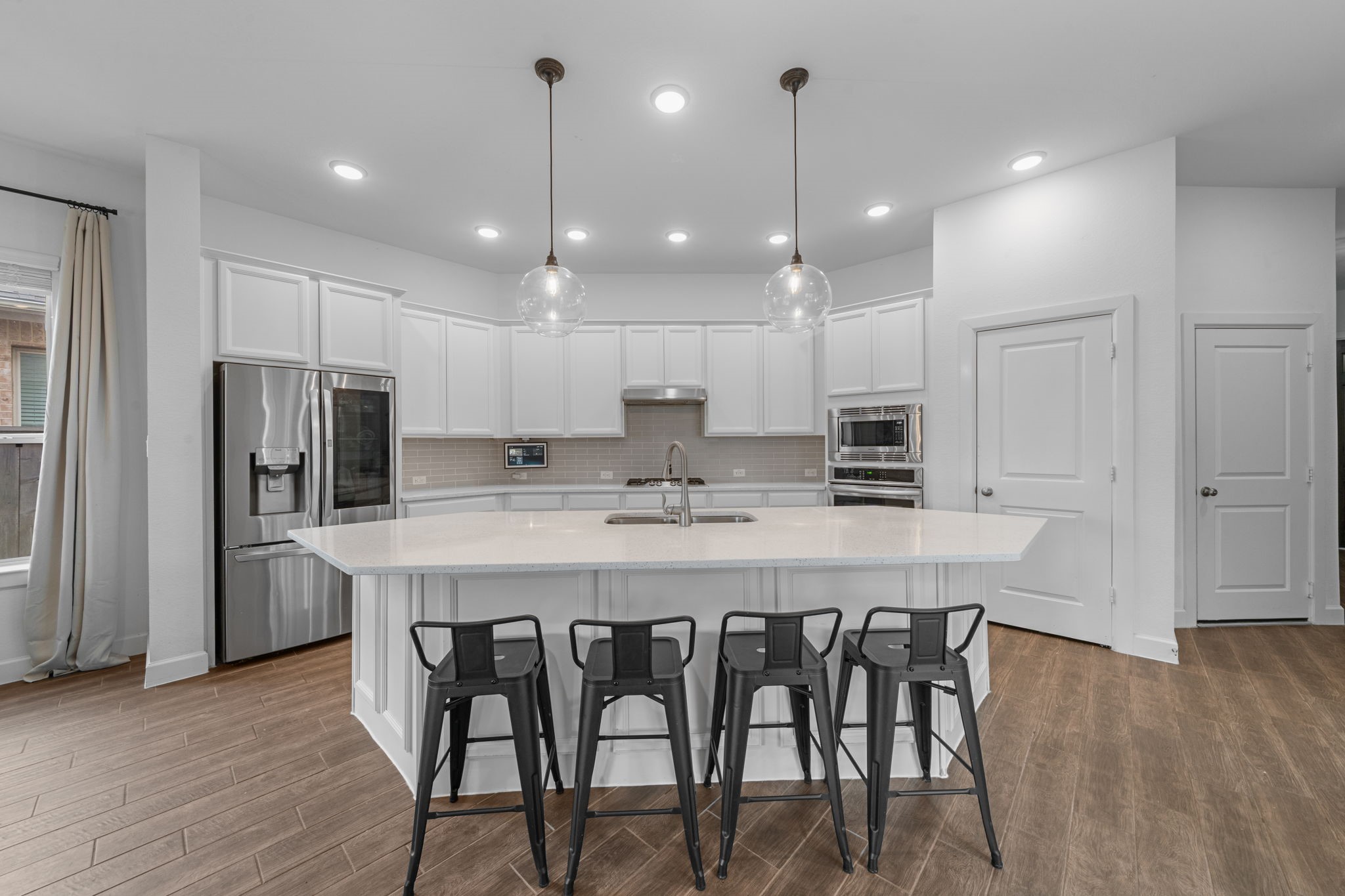 15119 Barbado Ridge Trail Cypress, TX 77433 - Photo 11 of 37 The kitchen features a massive center island with sink, crisp white cabinetry and beautiful quartz countertops, providing a generous workspace and a casual breakfast bar for four.