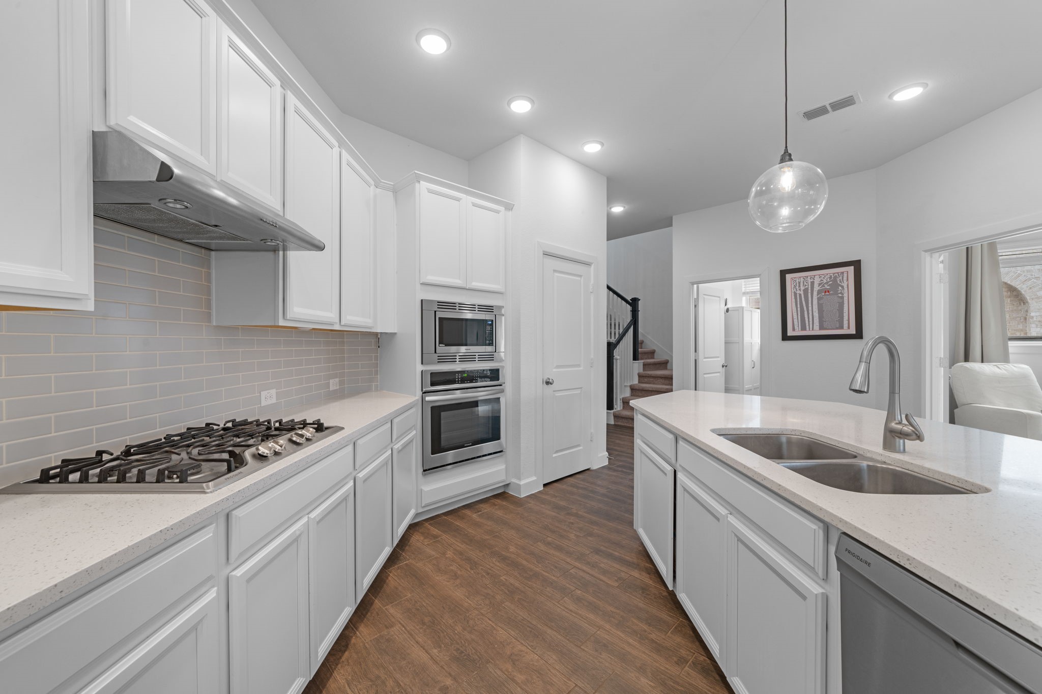 15119 Barbado Ridge Trail Cypress, TX 77433 - Photo 12 of 37 Equipped with premium stainless steel appliances, including a built-in oven, microwave, and a gas cooktop with a professional vent hood, this kitchen is ready for any culinary challenge.