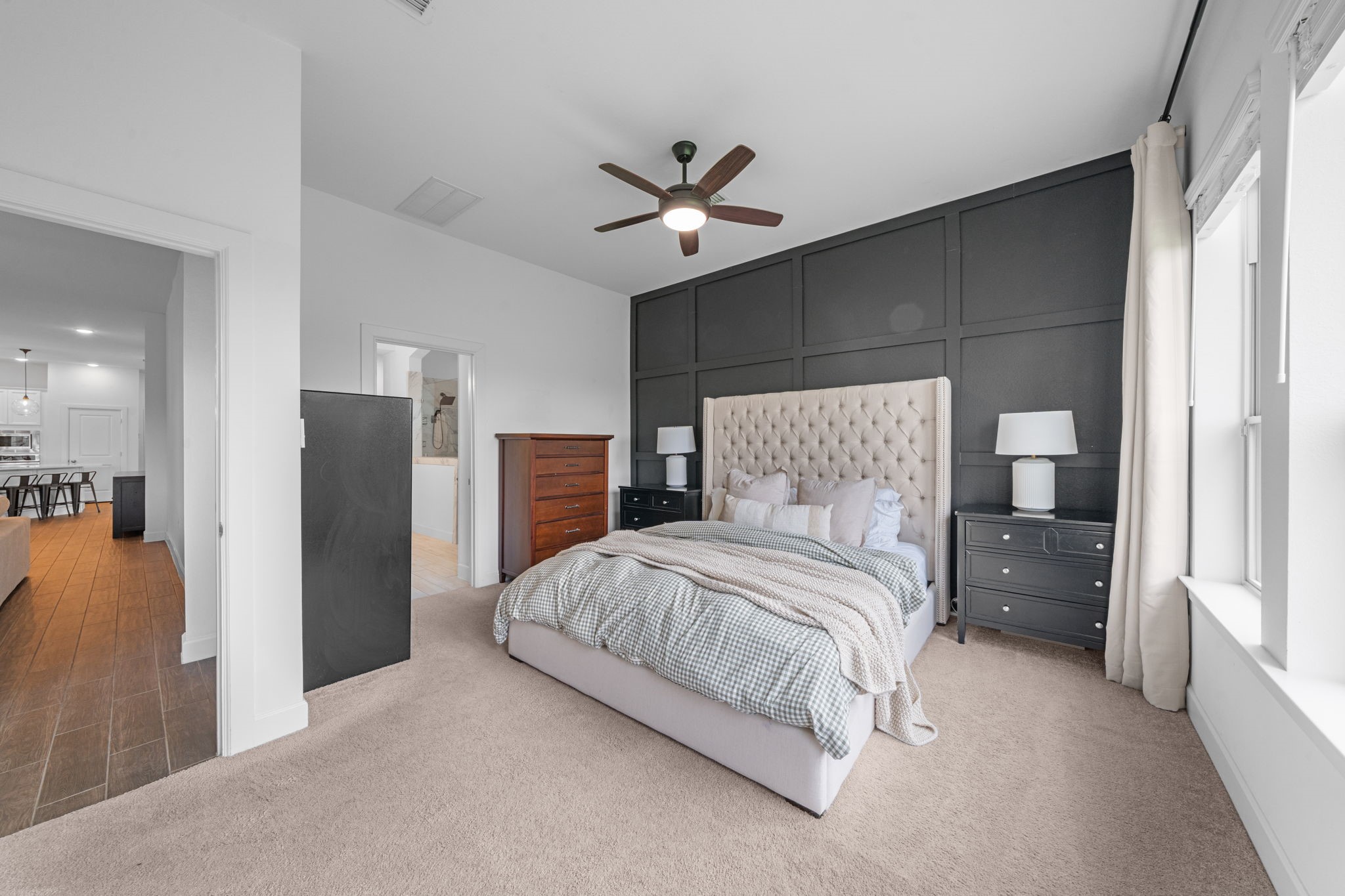 15119 Barbado Ridge Trail Cypress, TX 77433 - Photo 15 of 37 The primary suite is a true sanctuary, featuring a striking charcoal-grey accent wall with elegant board-and-batten detailing that adds a sophisticated, modern touch to the space.