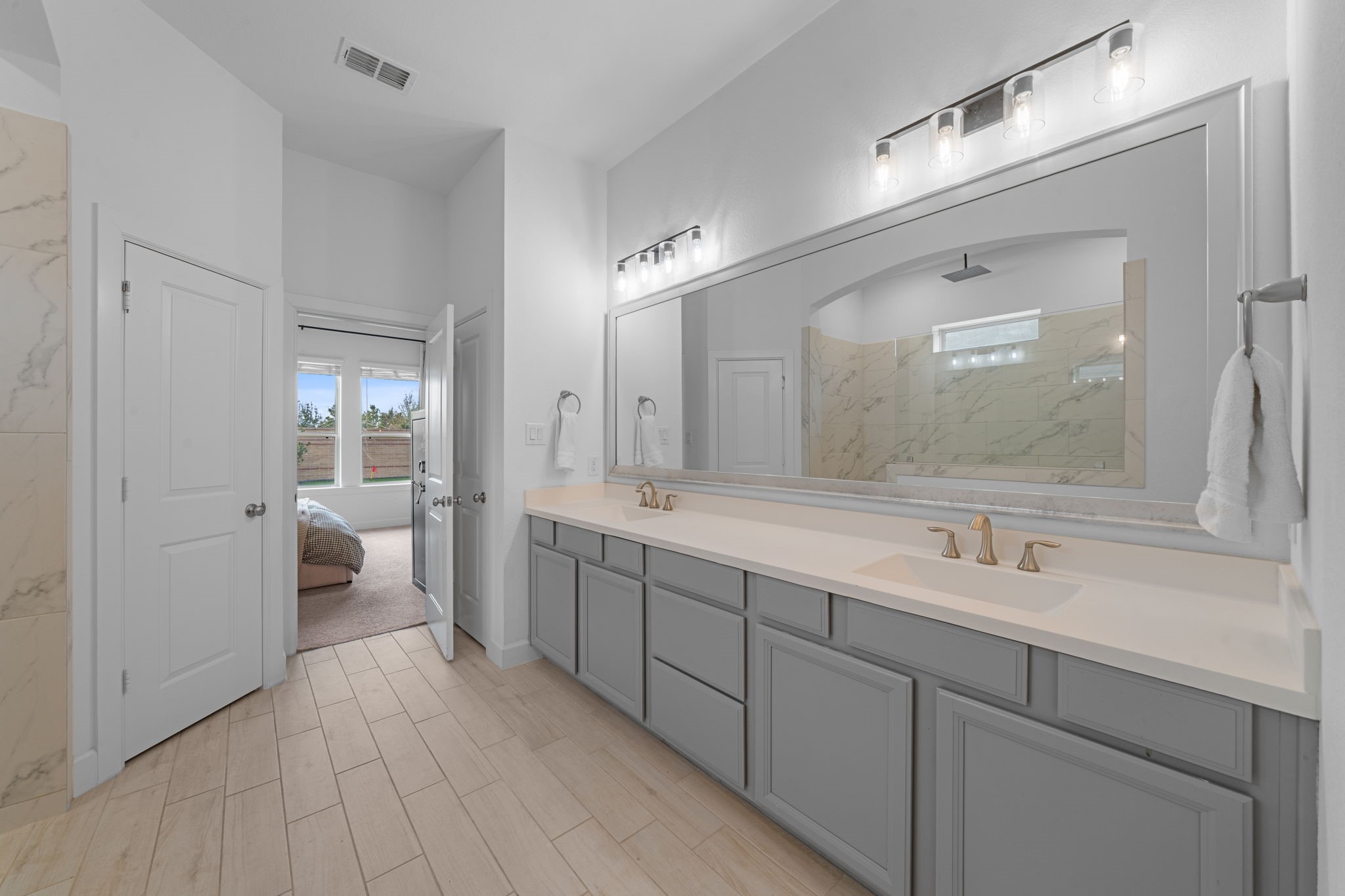 15119 Barbado Ridge Trail Cypress, TX 77433 - Photo 18 of 37 The expansive double vanity features stylish grey cabinetry paired with a crisp white countertop and dual sinks, offering plenty of space for morning routines.