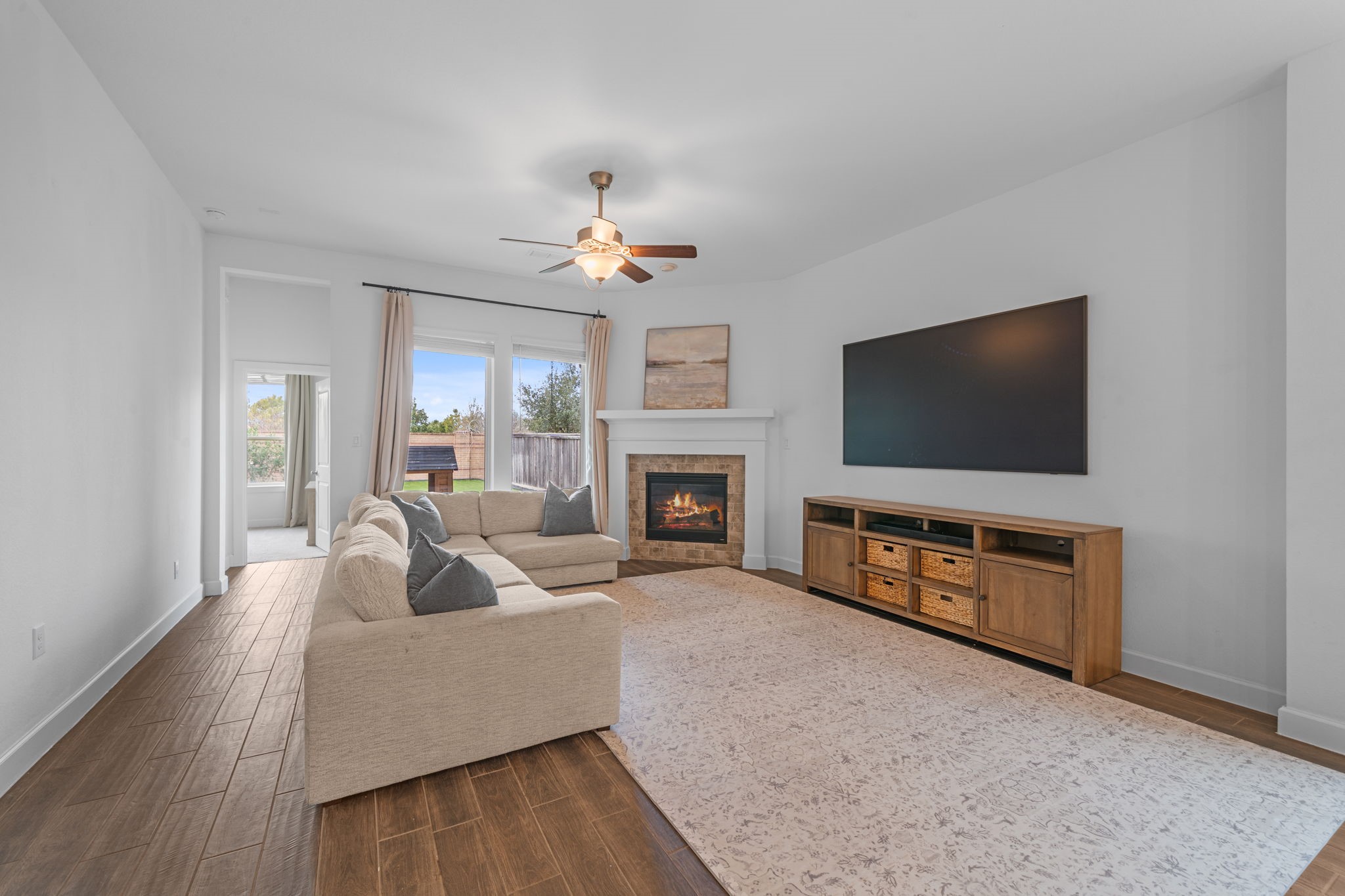 15119 Barbado Ridge Trail Cypress, TX 77433 - Photo 6 of 37 The focal point of the room is a beautiful stone-surround fireplace, perfect for cozying up during cooler evenings. Large windows flank the fireplace, framing views of the outdoors and flooding the room with natural light.