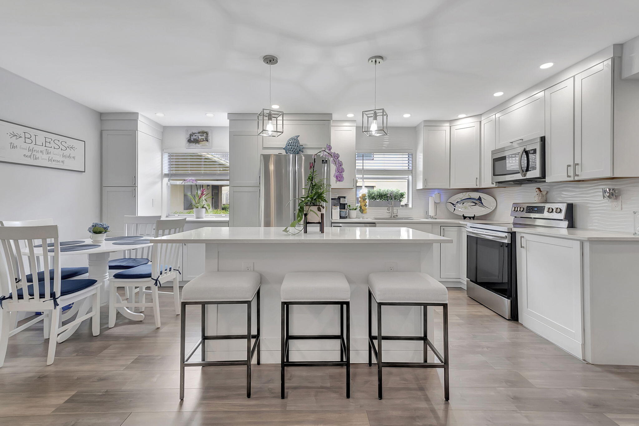 a kitchen with stainless steel appliances granite countertop a table chairs sink and cabinets