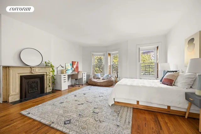 a bedroom with a bed next to a window with fireplace